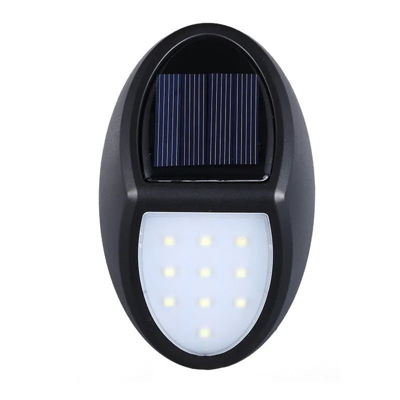 Black rectangular LED solar wall light mounted on an outdoor wall with a visible solar panel.