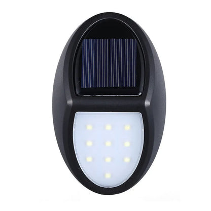 Black rectangular LED solar wall light mounted on an outdoor wall with a visible solar panel.