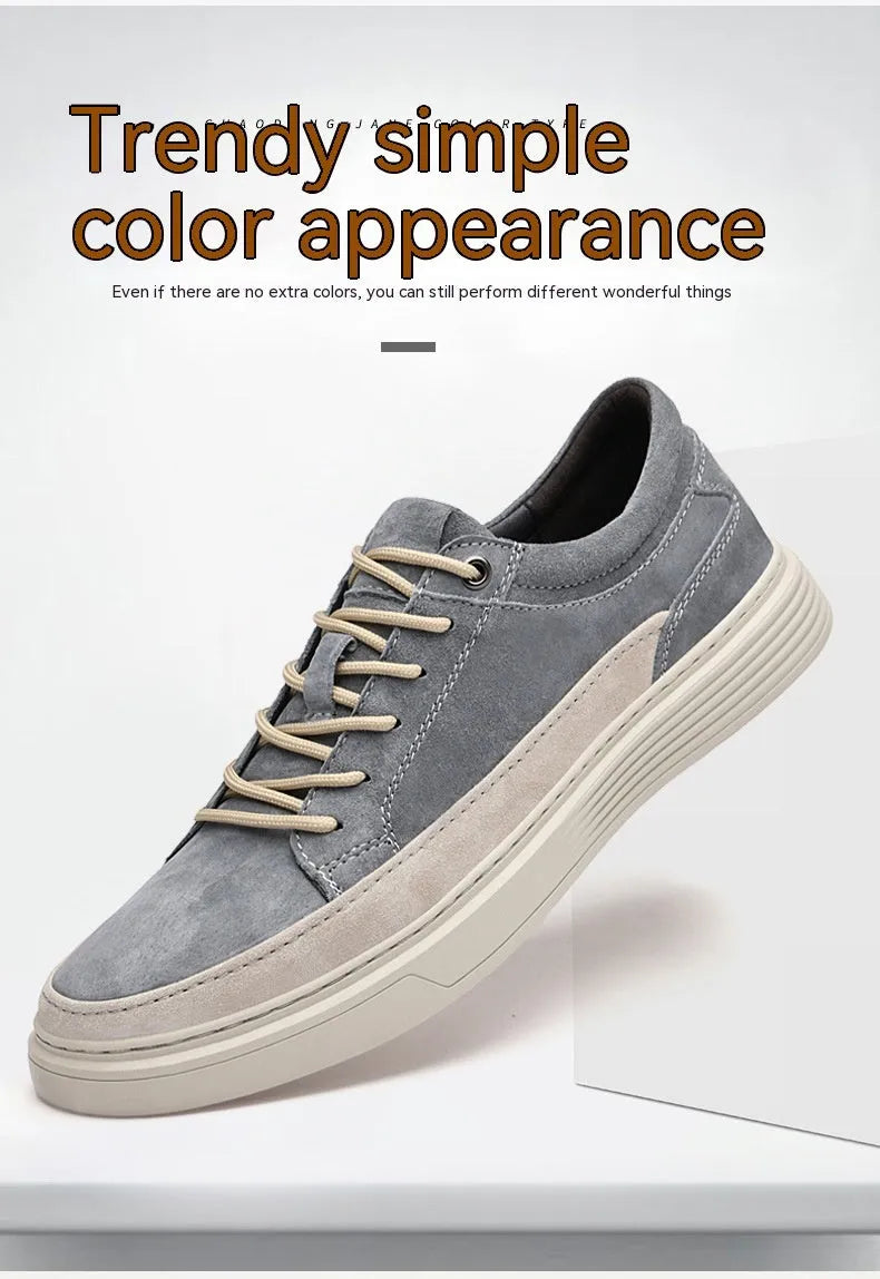 Men's grey low-top casual leather skate shoes with round toe and flat rubber sole on a wooden surface.