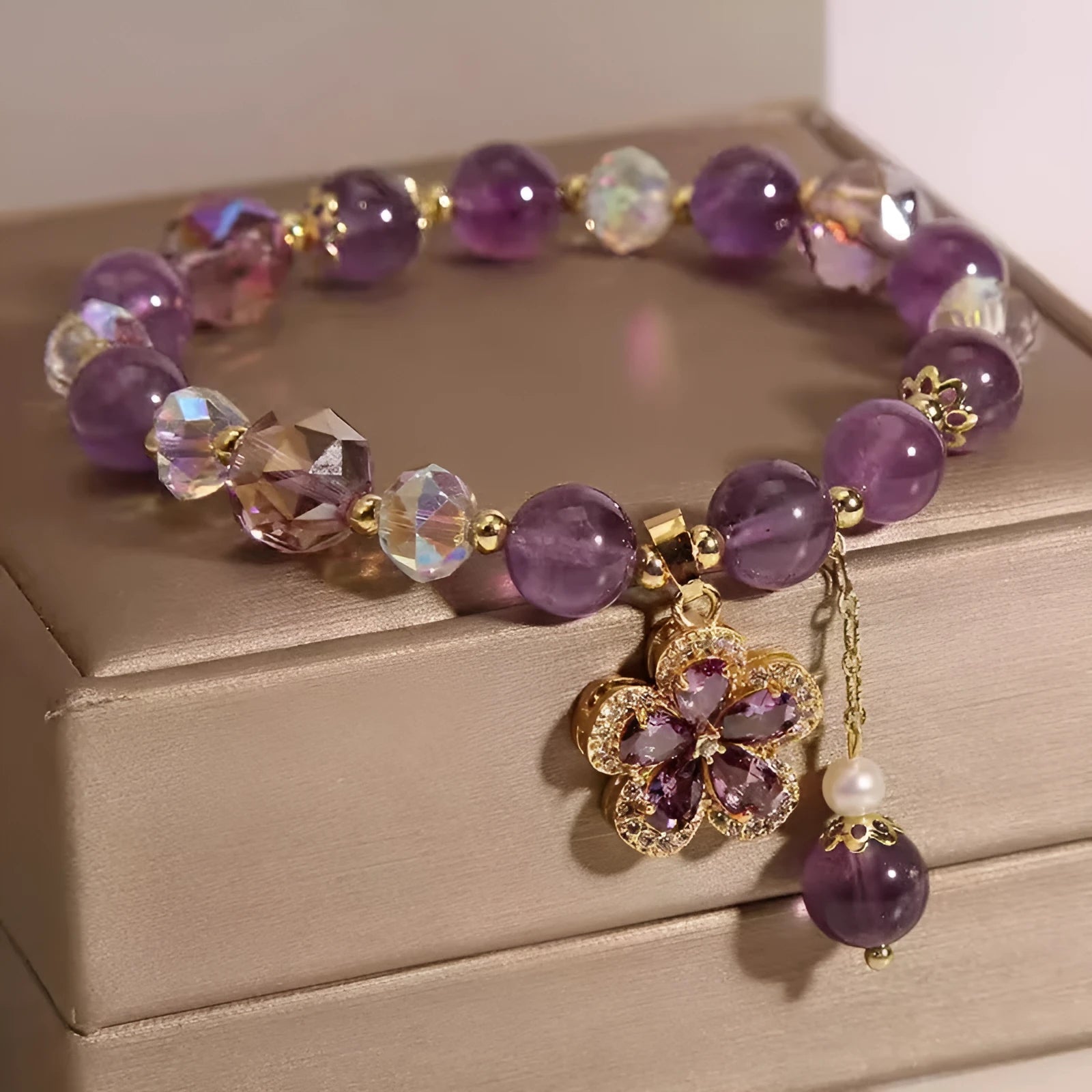 Natural purple amethyst crystal bracelet with nine-tailed fox and flower pendants on wrist.