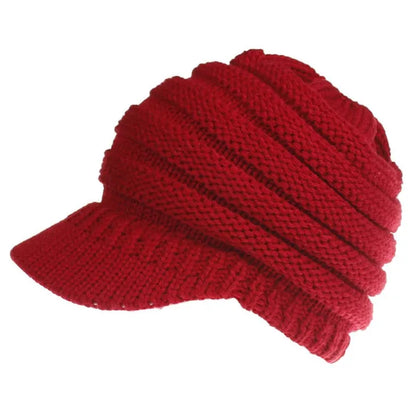 Woman wearing a light grey knitted ponytail beanie with her ponytail pulled through the hole in the back.