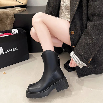 Women's black platform Martin ankle boots with square toe and back zip on a white background.