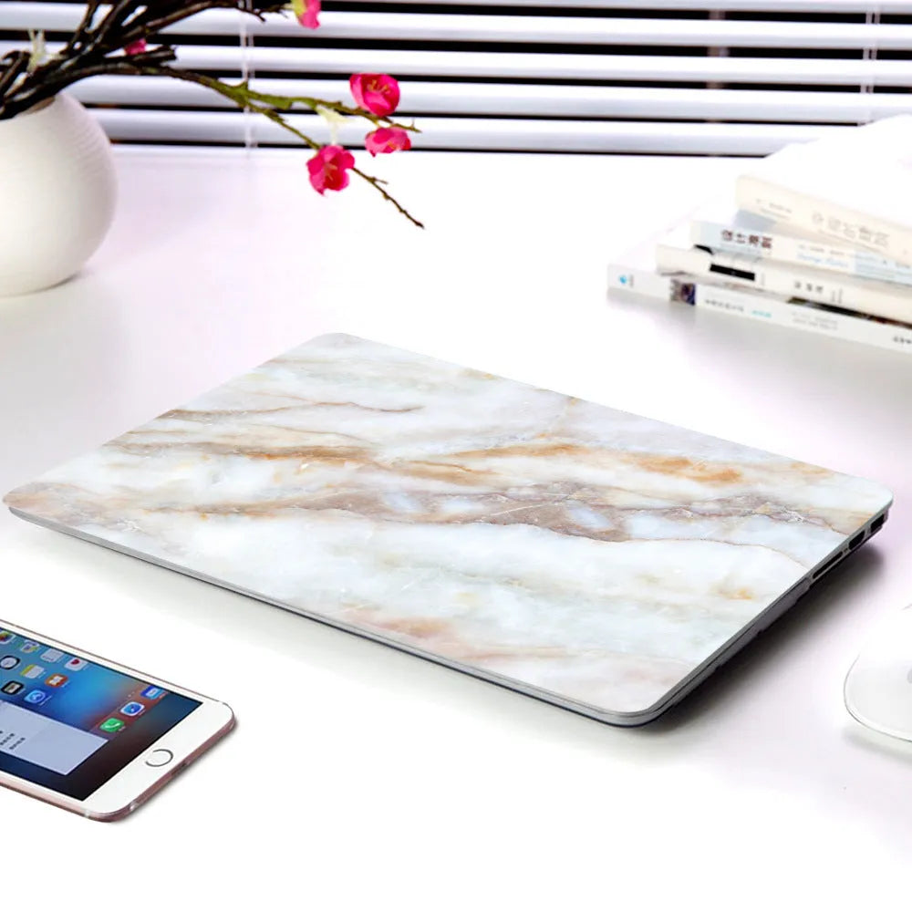 Plastic MacBook protective case in a marble pattern colour, shown next to a compatible Apple laptop.