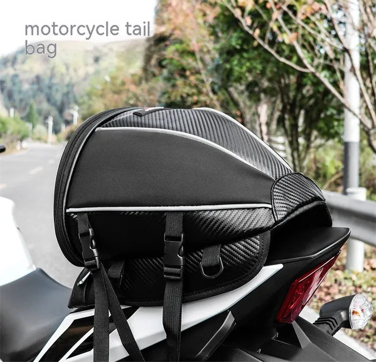 Black waterproof motorcycle tail bag with reflective stripe, showing multiple pockets and a carrying strap.