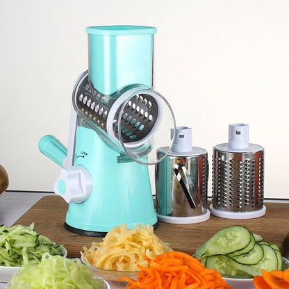Round mandoline vegetable slicer with three stainless steel blades and a rubber suction base, in blue green colour.