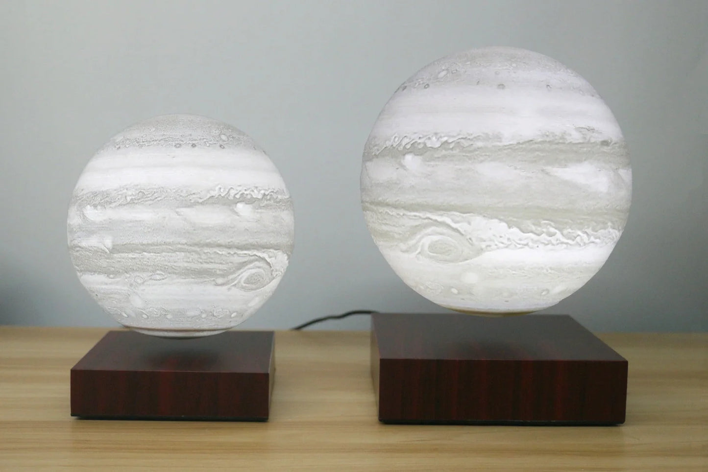 Levitating Earth or Jupiter lamp floating above base with LED illumination