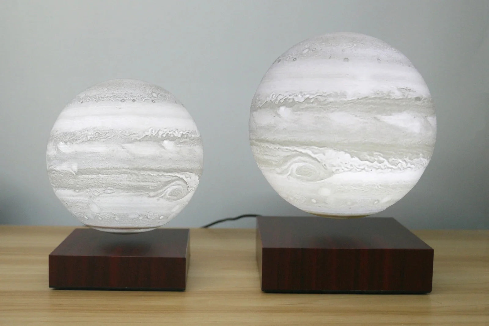 Levitating Earth or Jupiter lamp floating above base with LED illumination