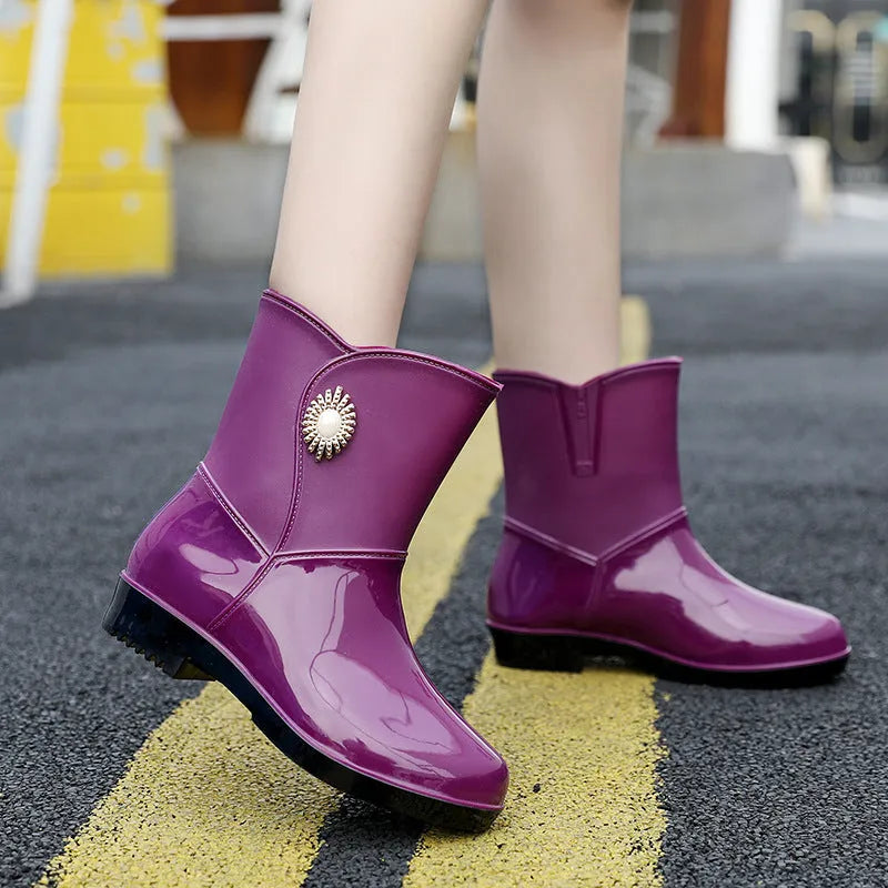Women's purple PVC rain boot with non-slip sole on a wet surface.