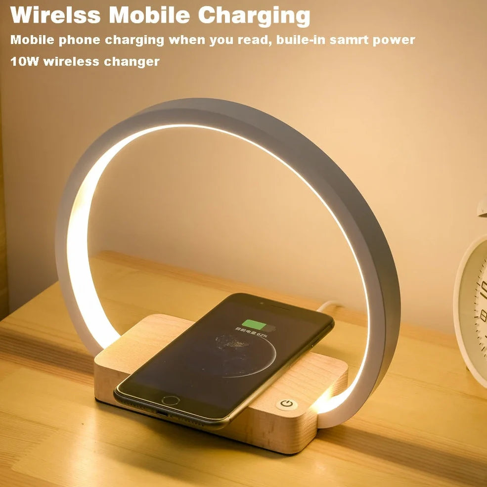 White wireless charging table lamp with metal shade and button switch on wooden surface