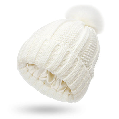 Cozy satin-lined knit beanie with plush faux fur pom-pom in various colors for women