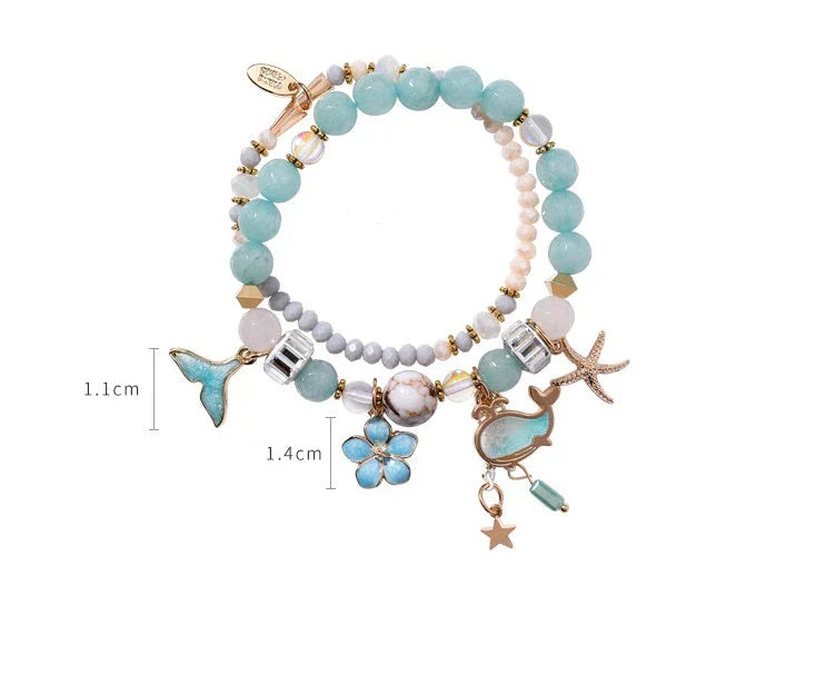 Elegant whale tail bracelet in vibrant colors with flower and starfish accents, perfect for adding a touch of coastal charm to any outfit.