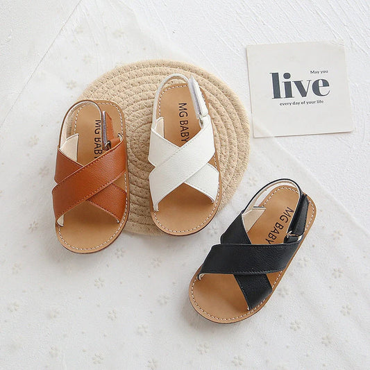 Children's black cross-strap sandals with adjustable Velcro fastening showing size range 21-30