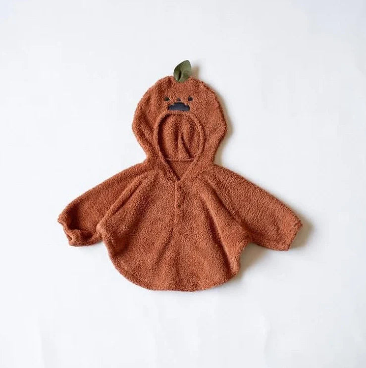 Baby wearing festival-themed plush top with hood and long sleeves in fleece fabric