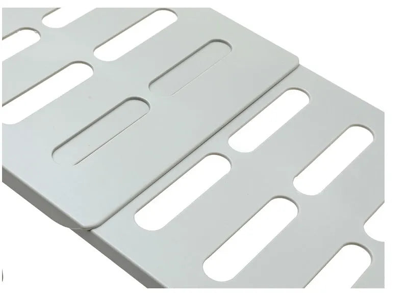 White telescopic kitchen storage rack at adjustable height on a countertop