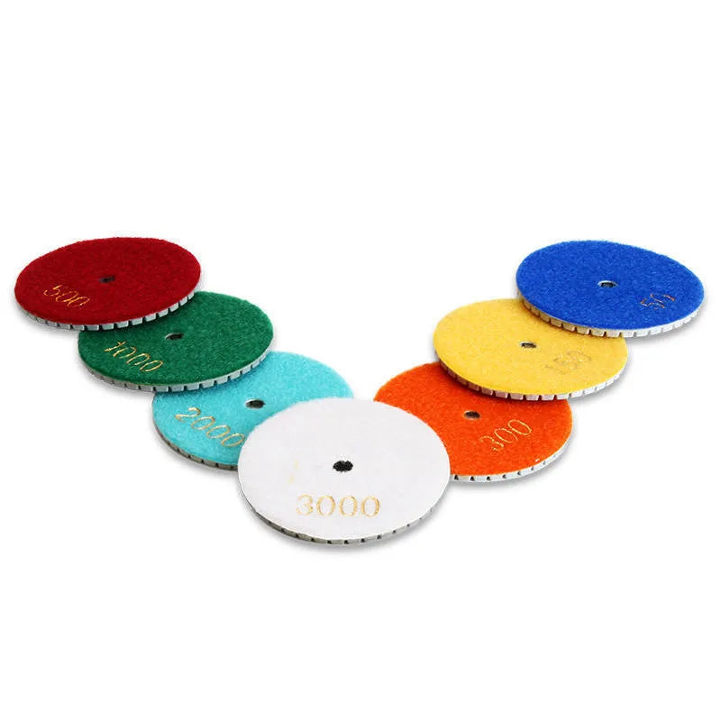 Set of 10 circular stone polishing pads with emery abrasive on a white background.