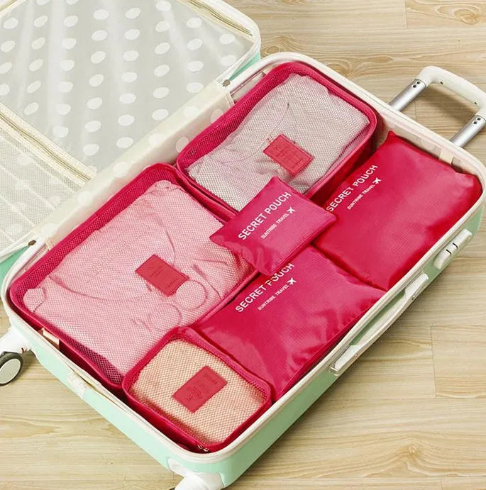 Set of six coloured nylon packing cubes and flat pouches for travel organisation.
