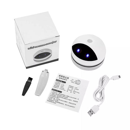 Compact USB charging wireless mini portable robot desktop vacuum cleaner on a desk