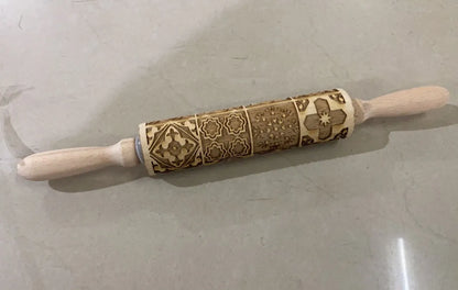 Wooden rolling pin with engraved Christmas patterns including reindeer and snowflakes on a 45cm long barrel.