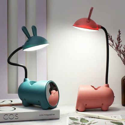 Modern green plastic USB table lamp with a long built-in pen holder on a wooden desk.