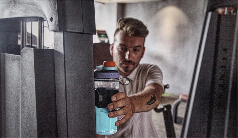 Magnetic sports water bottle with adjustable silicone grip that securely attaches to metal surfaces for hands-free hydration during workouts and outdoor activities