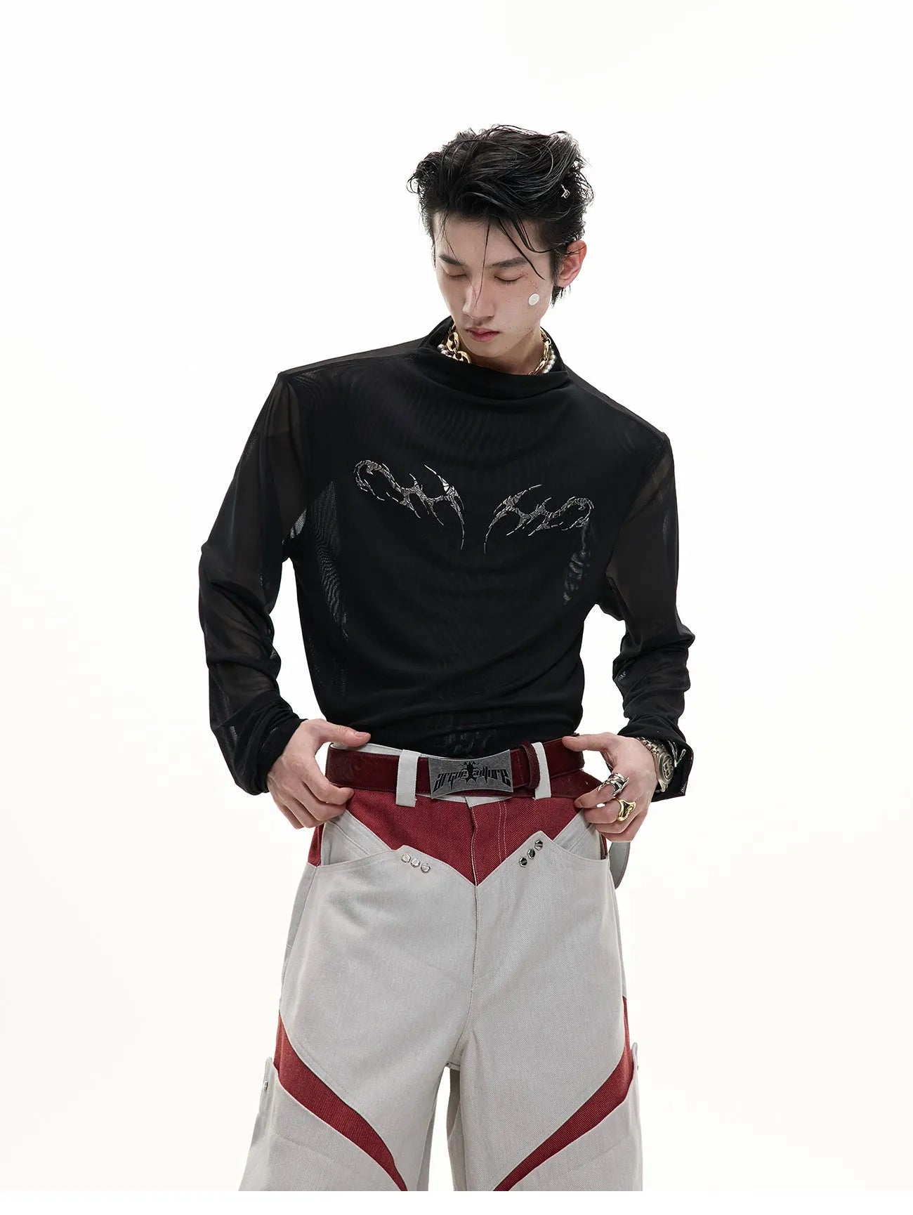 Man wearing a black slim-fit niche mesh long sleeve base layer shirt.