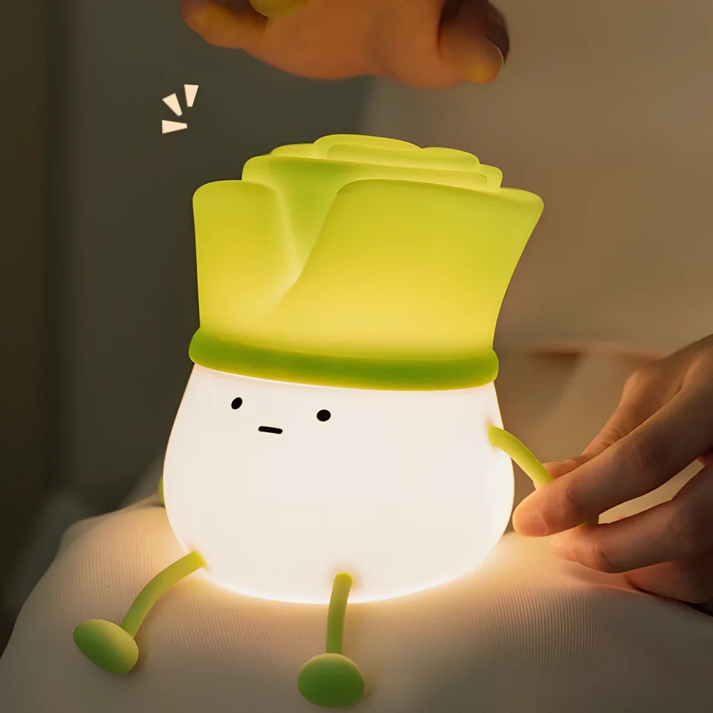 Green onion-shaped night light with warm white glow on desktop, showing 125mm width and flower design