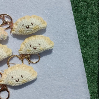Handmade crochet dumpling pendant with keychain showing plush texture and hand-stitched decorative eyes
