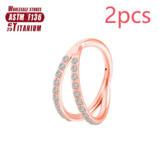 Pair of titanium alloy nose rings on a plain background showing silver, gold, black, and rose gold colour options.
