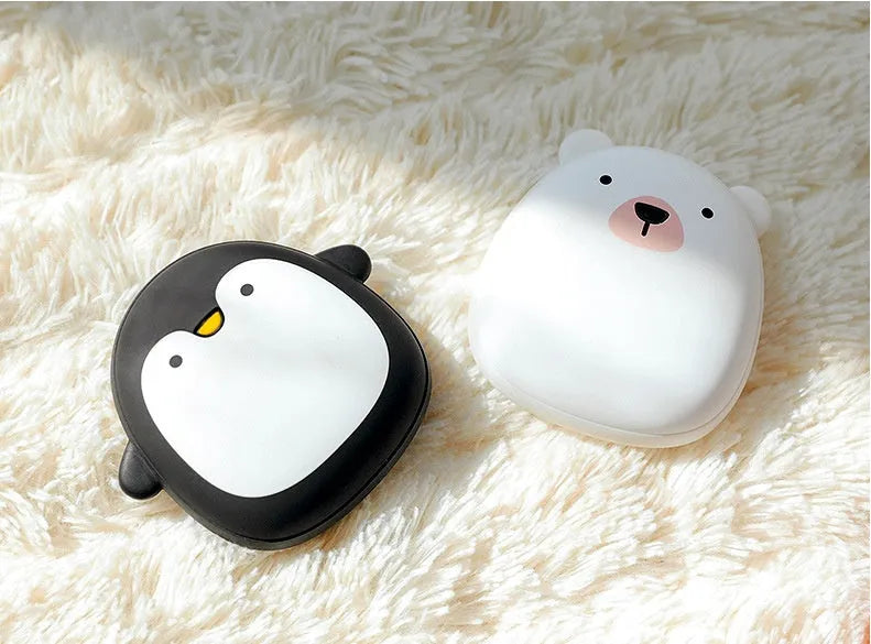 USB rechargeable electric hand warmers with double-side heating, pocket power bank capability, featuring cute cartoon penguin and polar bear designs, made from ABS plastic with baby skin-like silky texture and 5V/10W power rating, measuring 83×78×35mm.