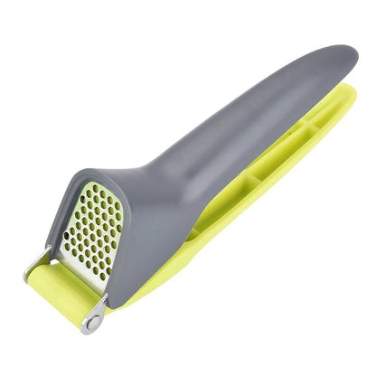 White plastic garlic masher with stainless steel crushing grid and ergonomic handle for kitchen use