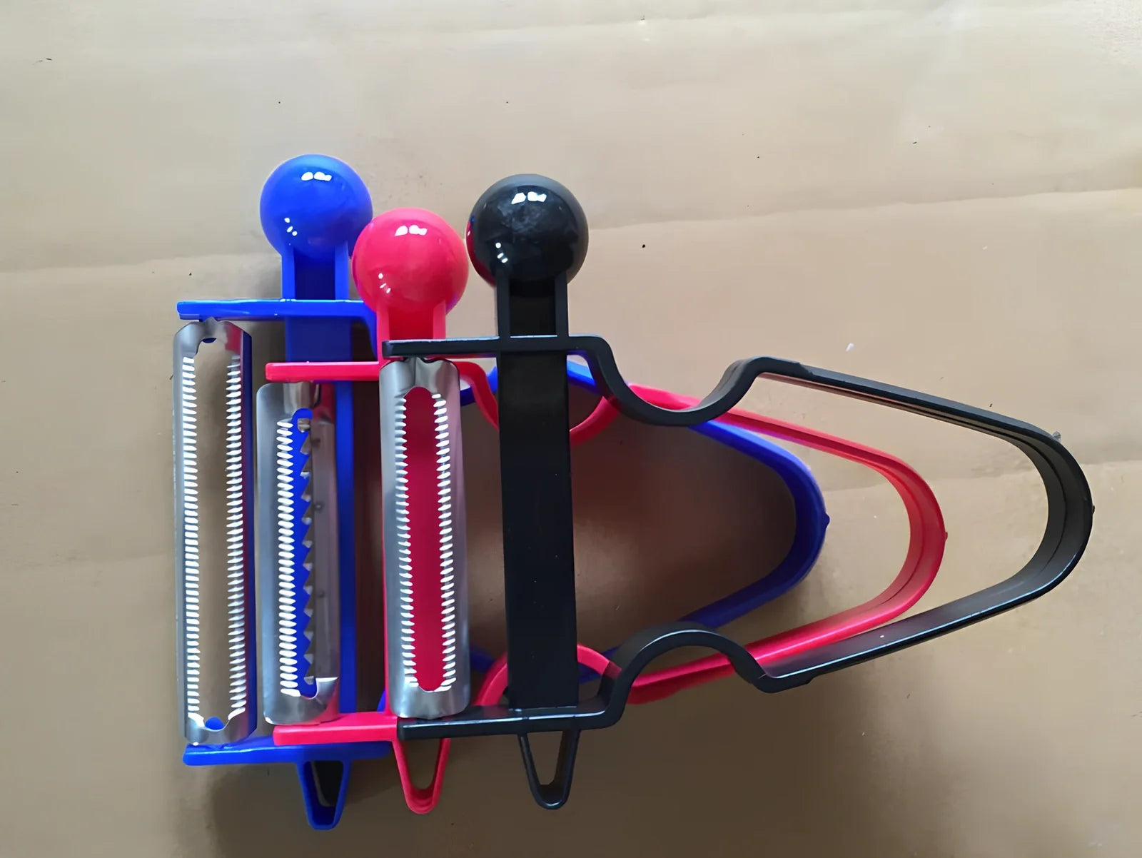 Stainless steel vegetable peeler set with black, blue, red handles and dual swivel blades