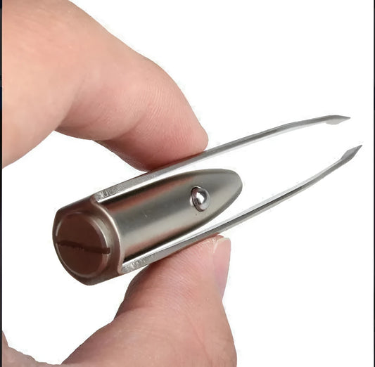 Close-up of stainless steel LED eyebrow tweezers with illuminated tip and push-button switch.