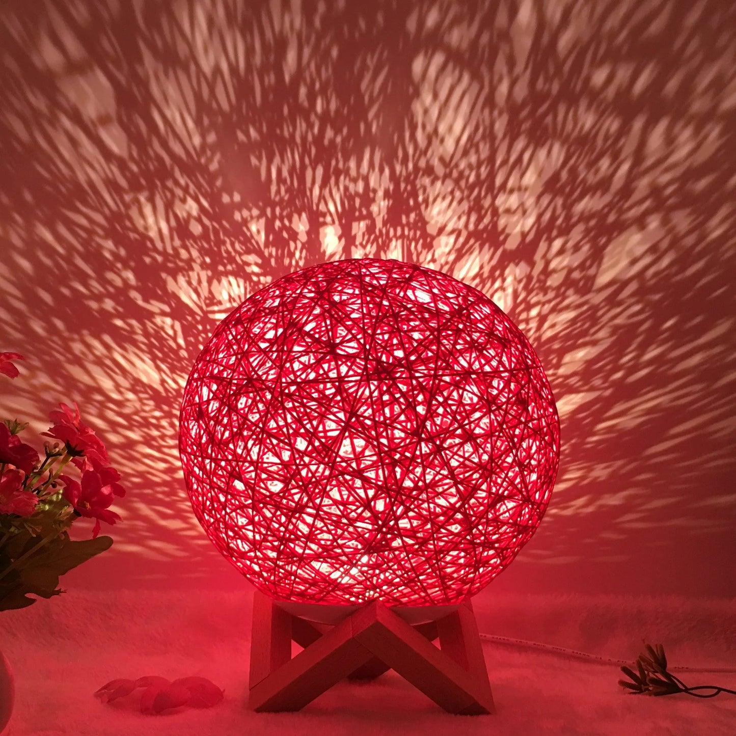Spherical hand-knitted rattan table lamp with remote control on a wooden desk