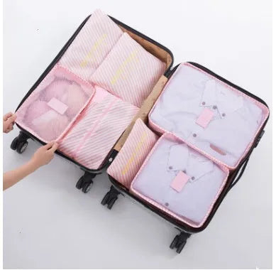 Set of six coloured nylon packing cubes and flat pouches for travel organisation.