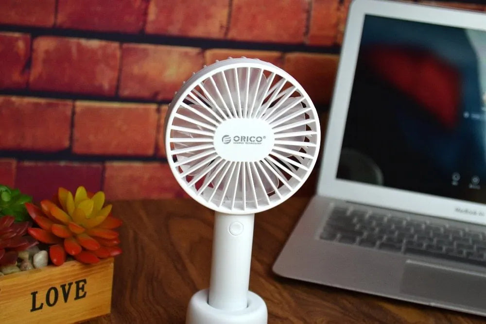 White ORICO FH1 portable USB desk fan with rechargeable battery on a wooden desk