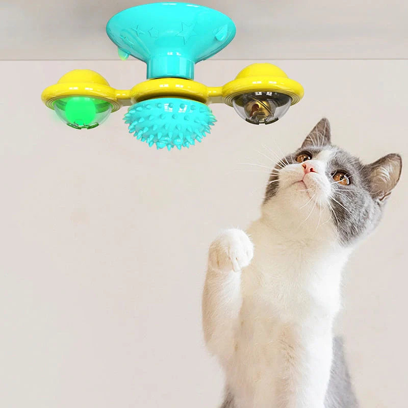 Cat playing with rotating windmill toy featuring suction base and luminous ball