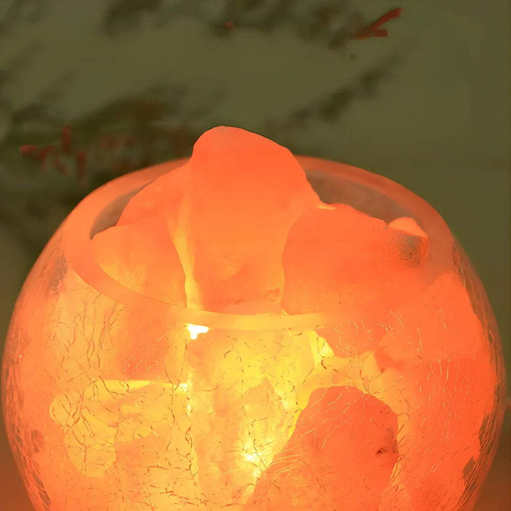 Crystal salt bedside lamp with glass shade and USB cable on wooden table