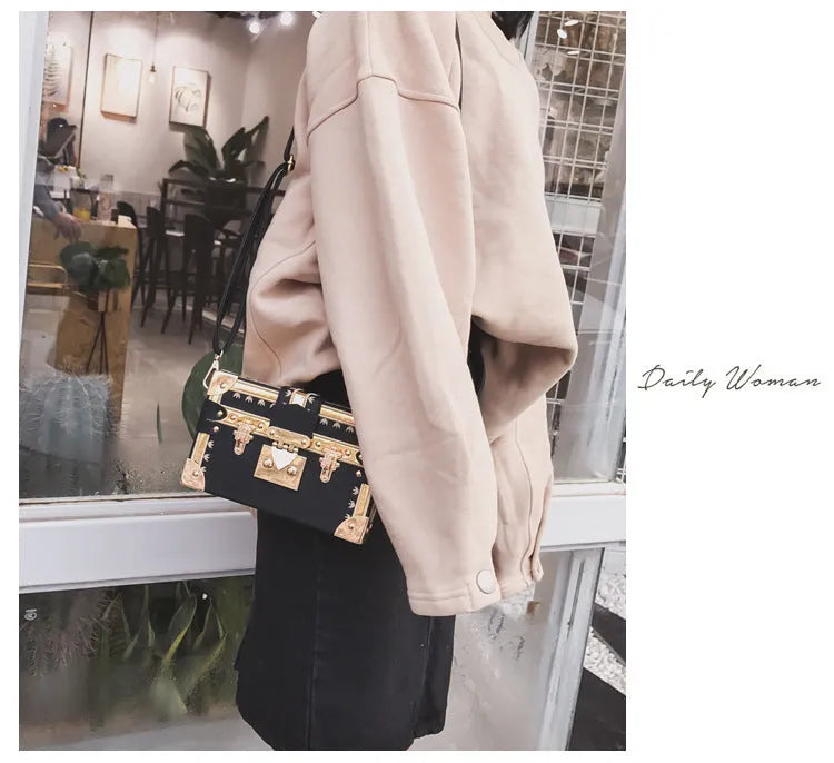 Women's hard flap shoulder bag in black or green with single adjustable strap and rivet decoration