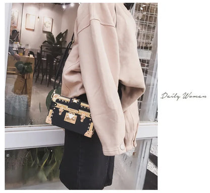 Women's hard flap shoulder bag in black or green with single adjustable strap and rivet decoration