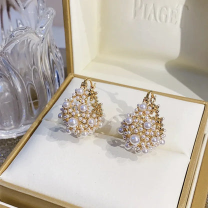 Gold-colour copper flower basket earrings with small rice-shaped bead inlay detail.