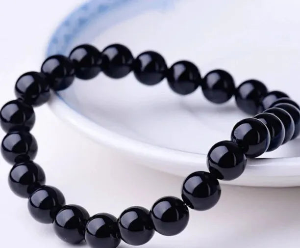 Geometric black agate bracelet for women with 8mm beads on a black elastic cord.