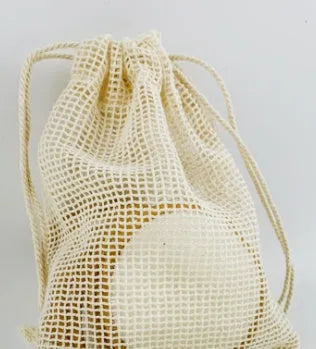 Set of water pink and light blue velvet makeup remover pads next to a cotton mesh storage bag.