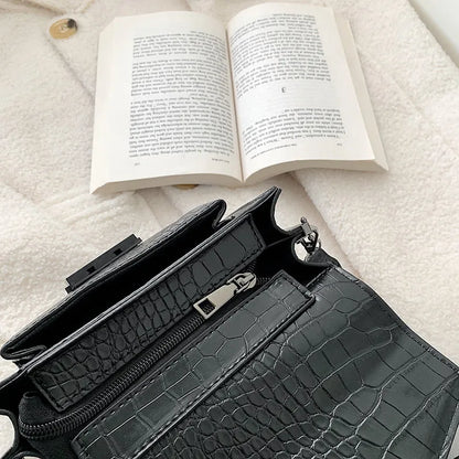 Vintage crossbody bag in black showing 20cm width, crossbody strap, and front storage compartment