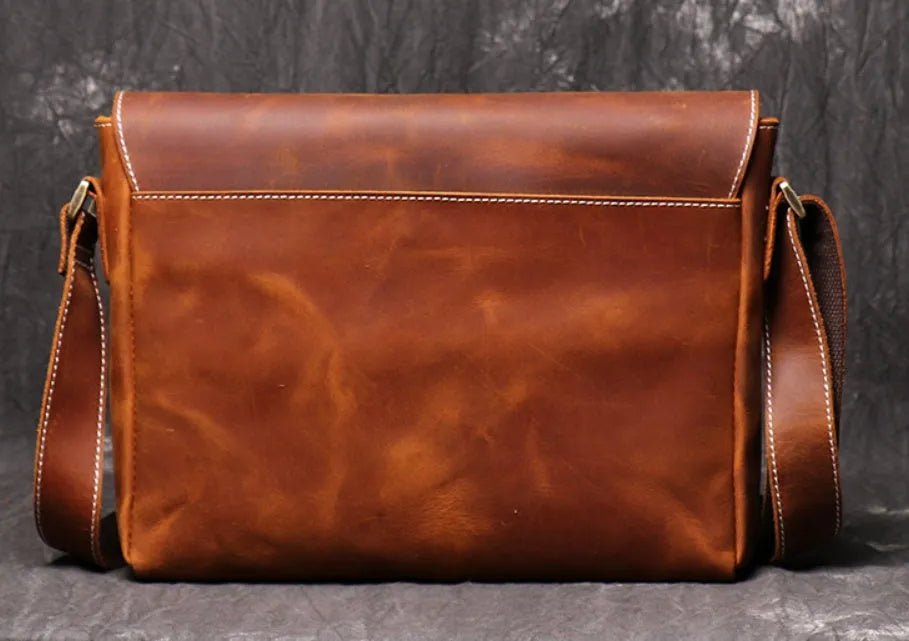 Vintage brown leather mens messenger bag with flap open, showing internal phone pouch and zipper pocket.
