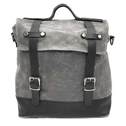 Black waterproof canvas motorcycle side bag with cowhide accents showing mounting straps