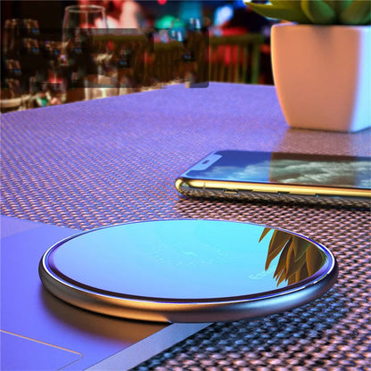 Black wireless charger on table with phone charging, showing blue LED light and anti-slip surface