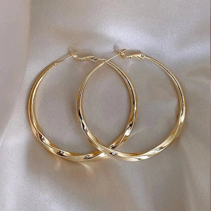 Twisted eyelet earrings in gold or silver electroplated metal, simple style, one pair