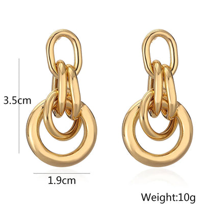 Geometric gold-coloured copper earrings with irregular asymmetric design