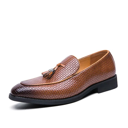 Men's black pointed toe slip on shoe with a decorative tassel on the artificial PU upper.