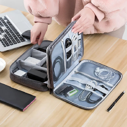 Gray waterproof electronics organiser bag open showing double-layer compartments with elastic loops and mesh pouches